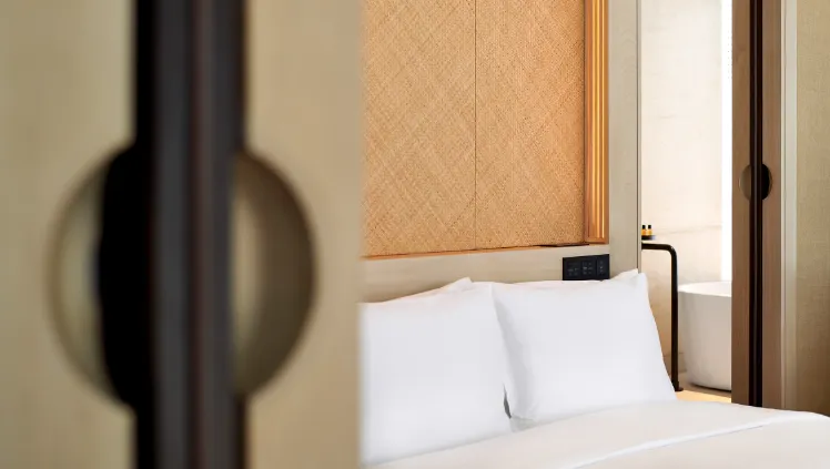 An elegant guest room at RuMa Hotel with a luxurious bed, modern decor, and warm lighting